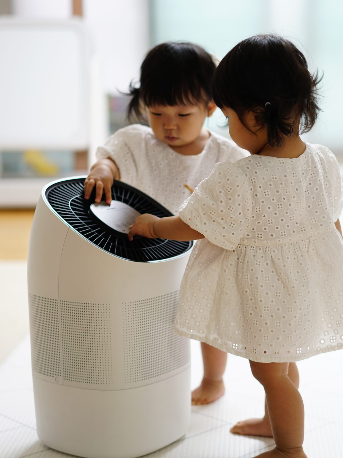 Two twin girl toddlers curiously touching Zenwell appliance touch display