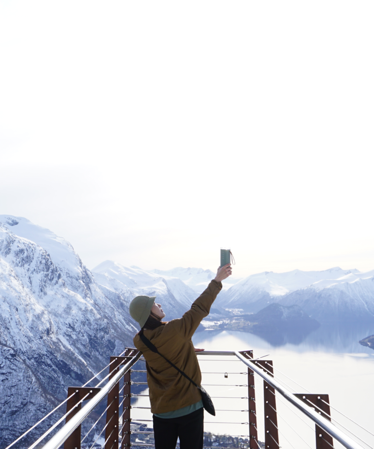 Woman raising Zenwell Air Doctor upwards towards the sky while standing atop a alpine observation deck