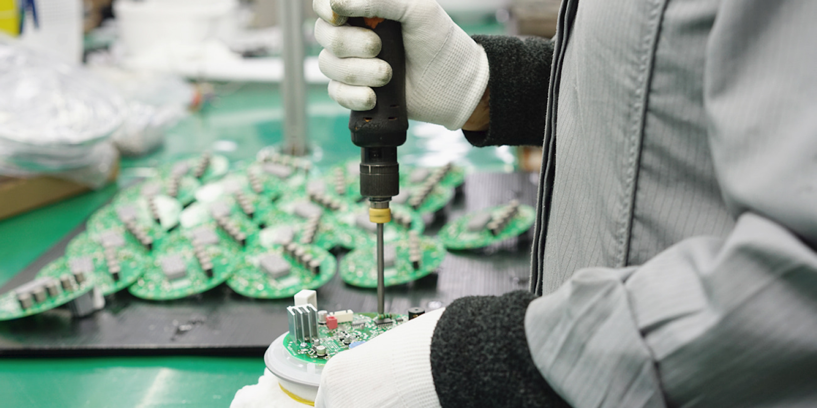 Worker assembling circuit board with screw driver