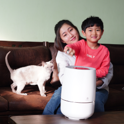 Happy mom, son, and cat on couch with Zenwell appliance in front of them