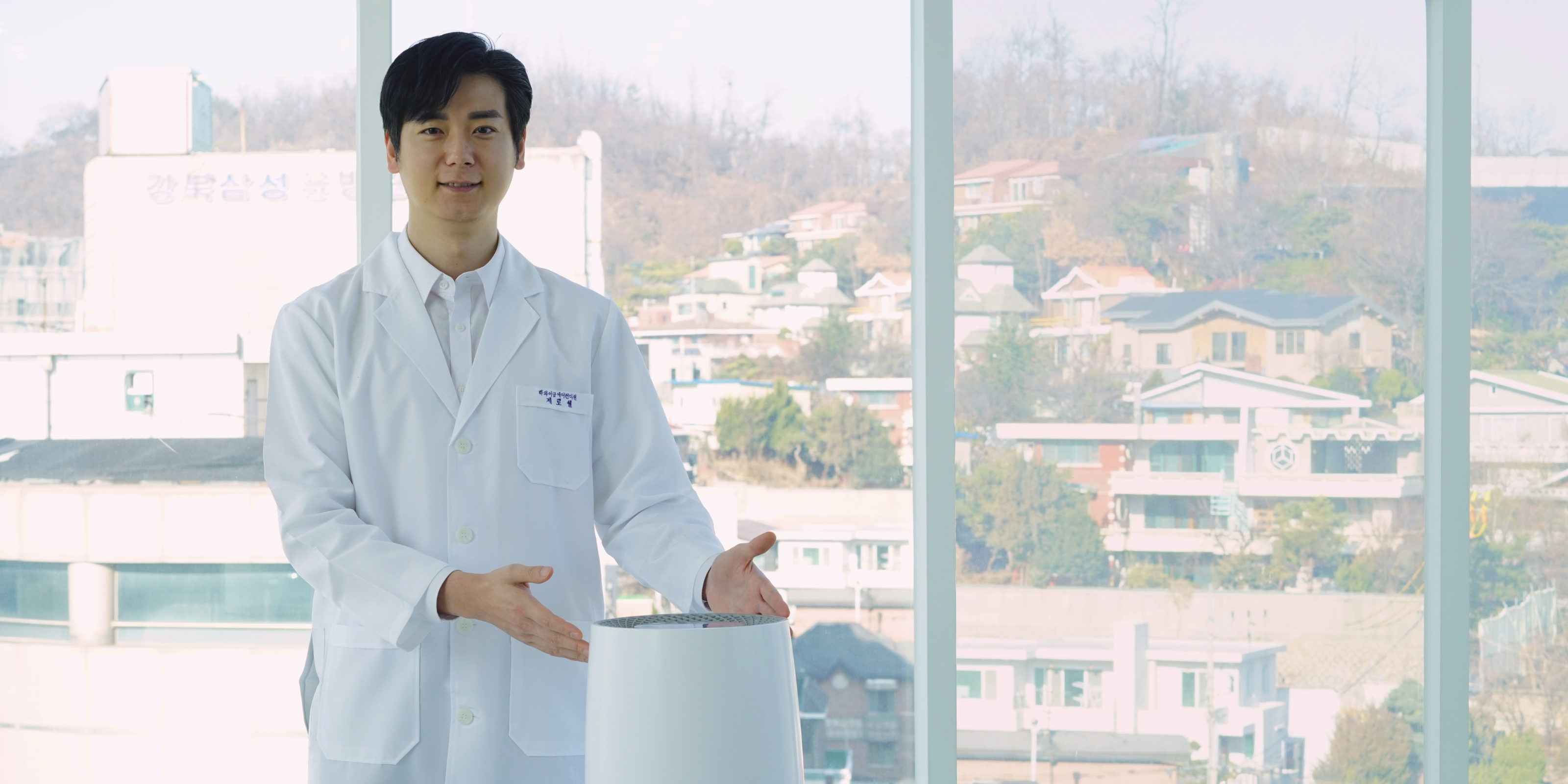 Company founder in lab coat gesturing to Zenwell appliance