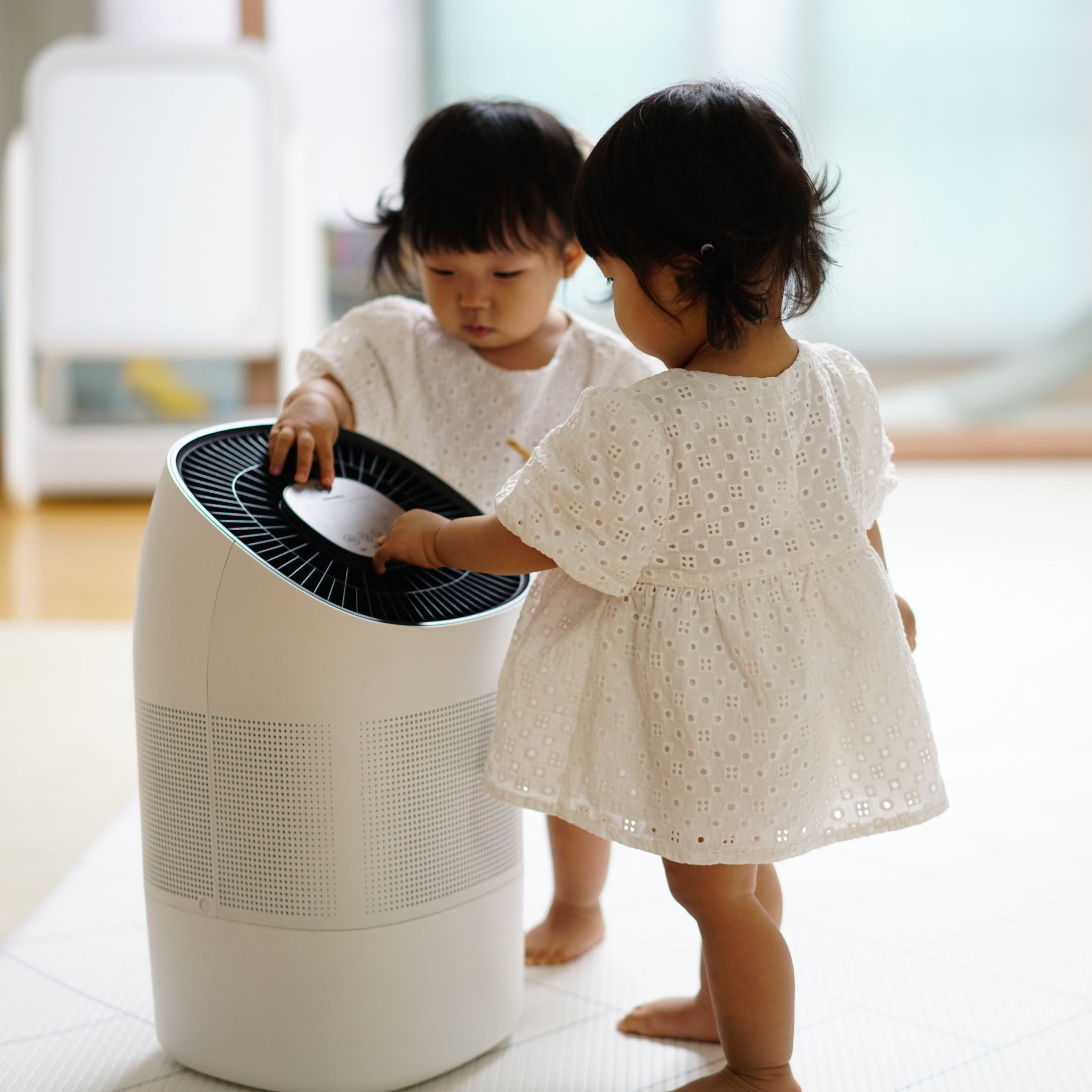 Two twin girl toddlers curiously touching Zenwell Super Air Purifier + Humidifier Smart touch display