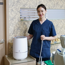 Doctor standing with Zenwell appliance in dental examination room